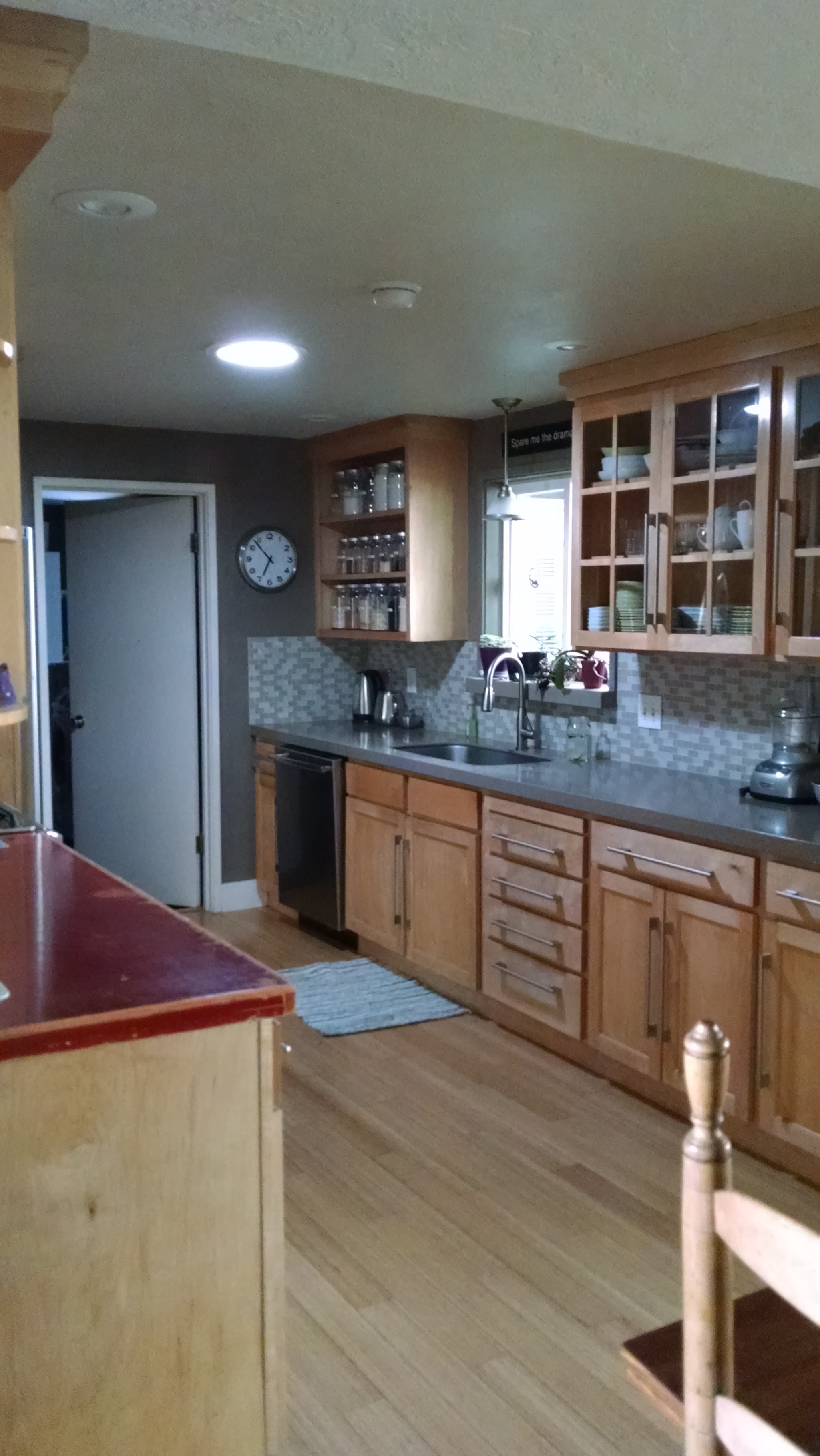 Kitchen remodel with glass-front cabinets and tile backsplash