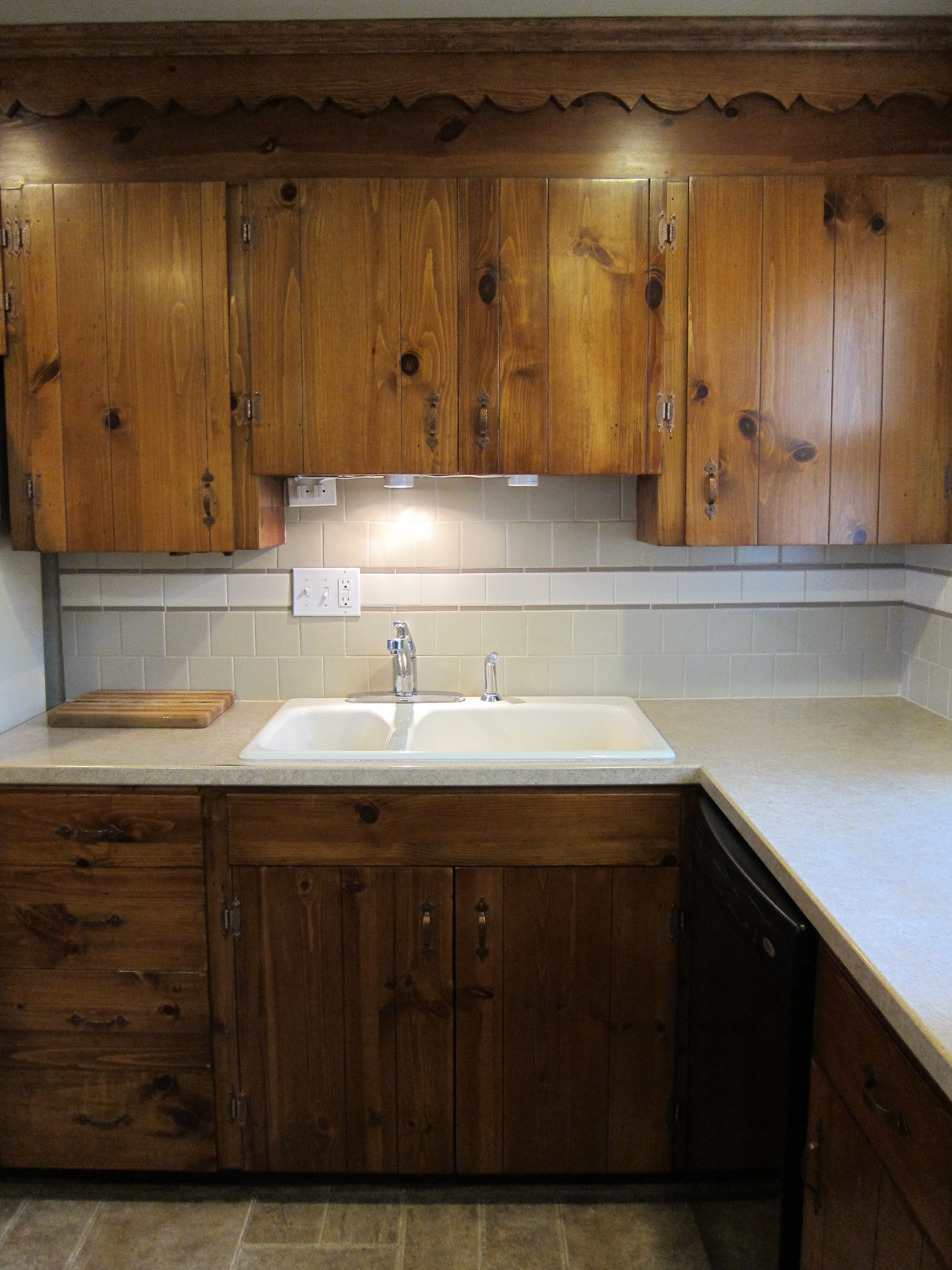 Detail of knotty pine kitchen cabinetry and tile backsplash
