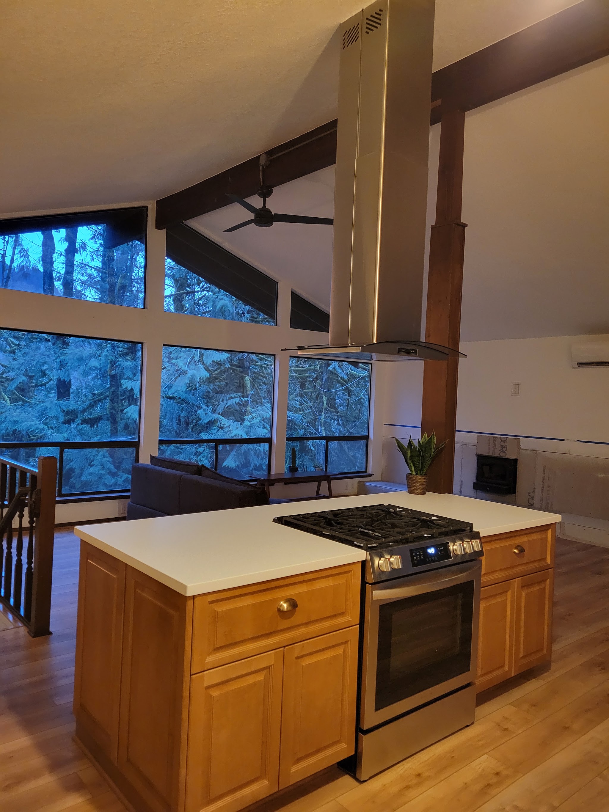 Vaulted great room addition with a kitchen island and forest view
